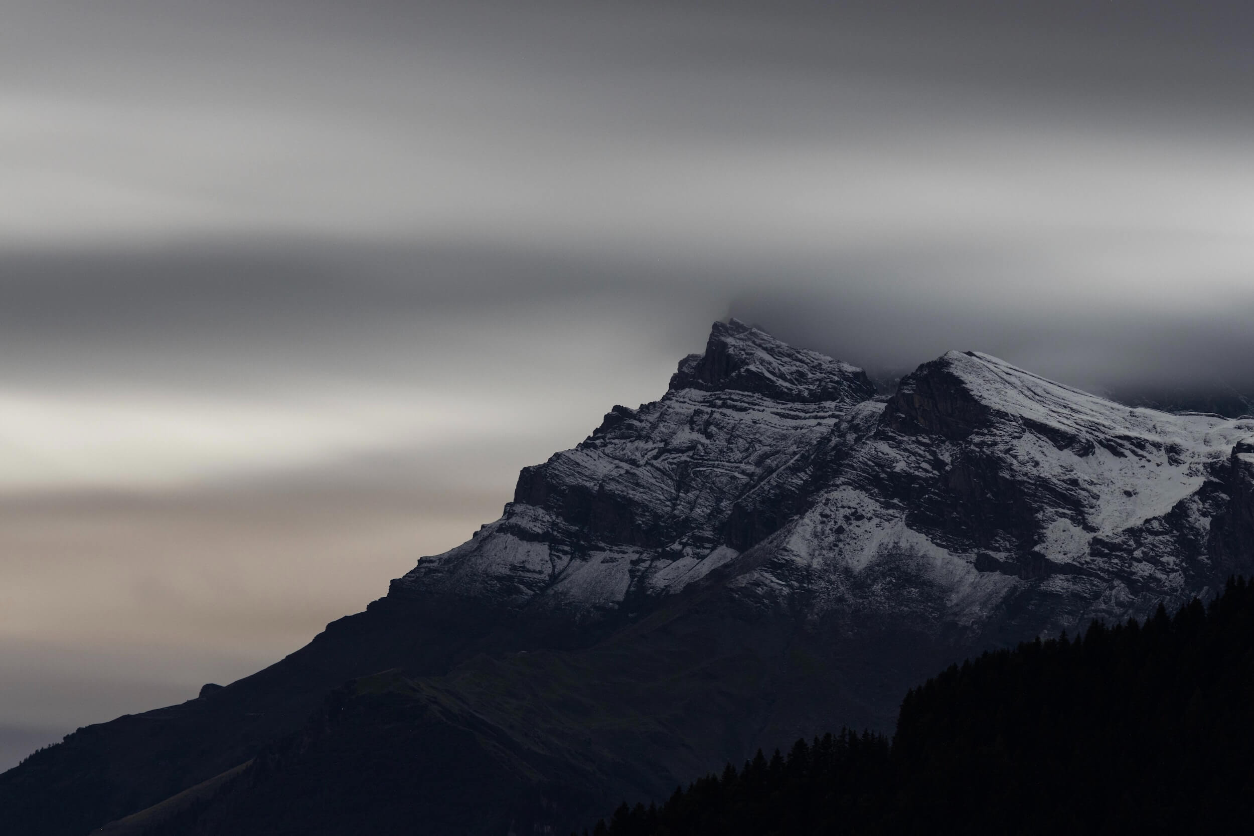 Overcast sky over a snowy mountain peak.